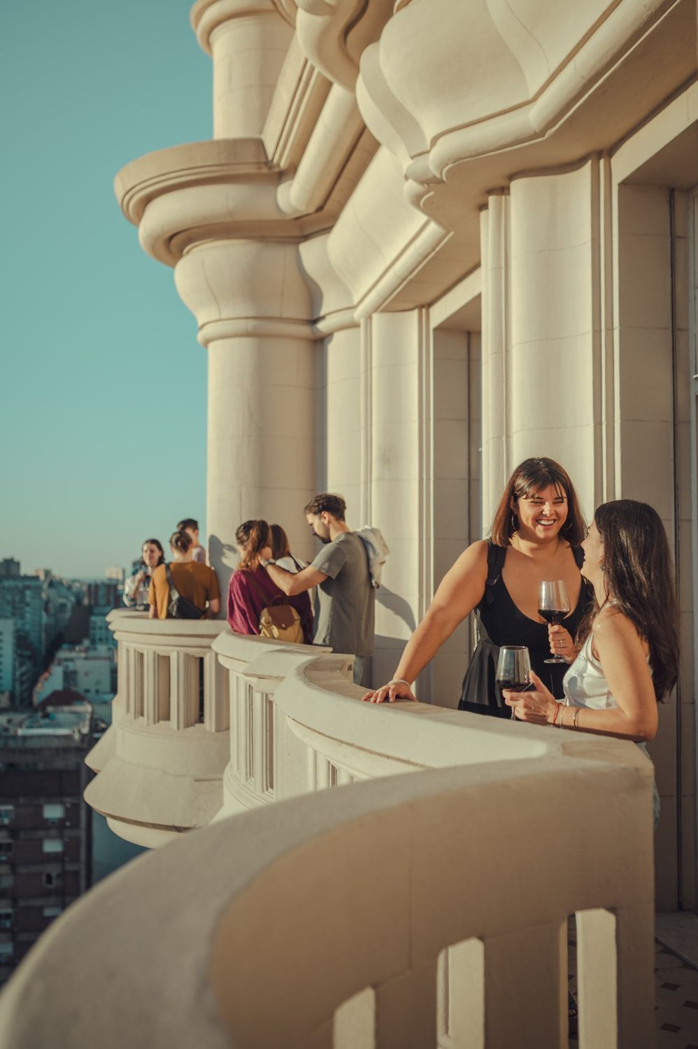 Dos amigas con una copa de vino en el balcón del Palacio Barolo