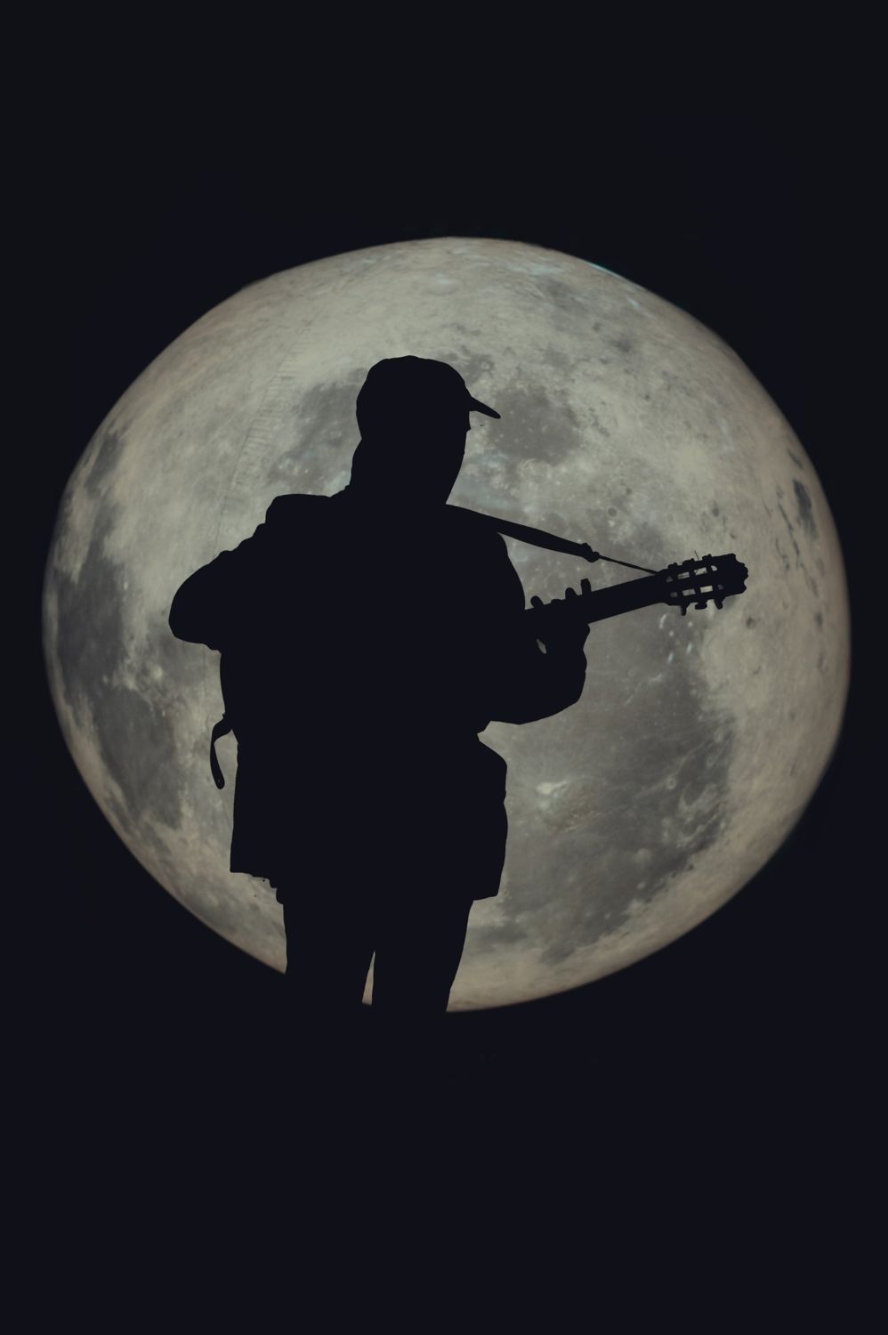 Guitarrista a contraluz frente a la luna