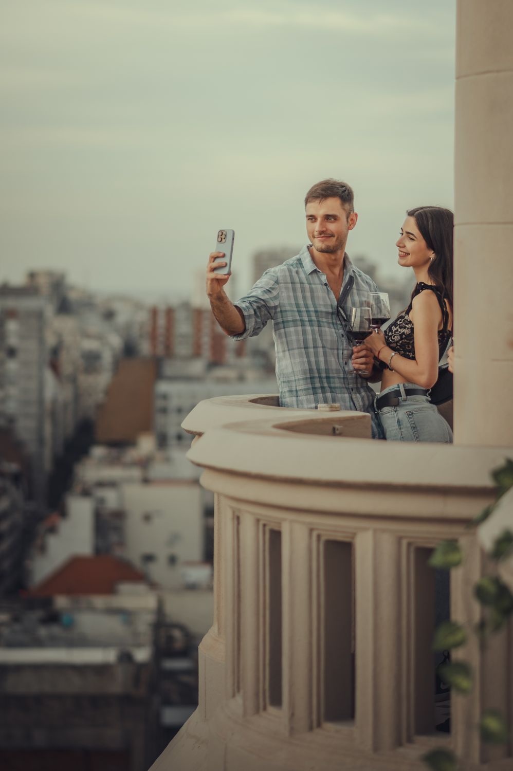 Pareja con copas de vino sobre la ciudad